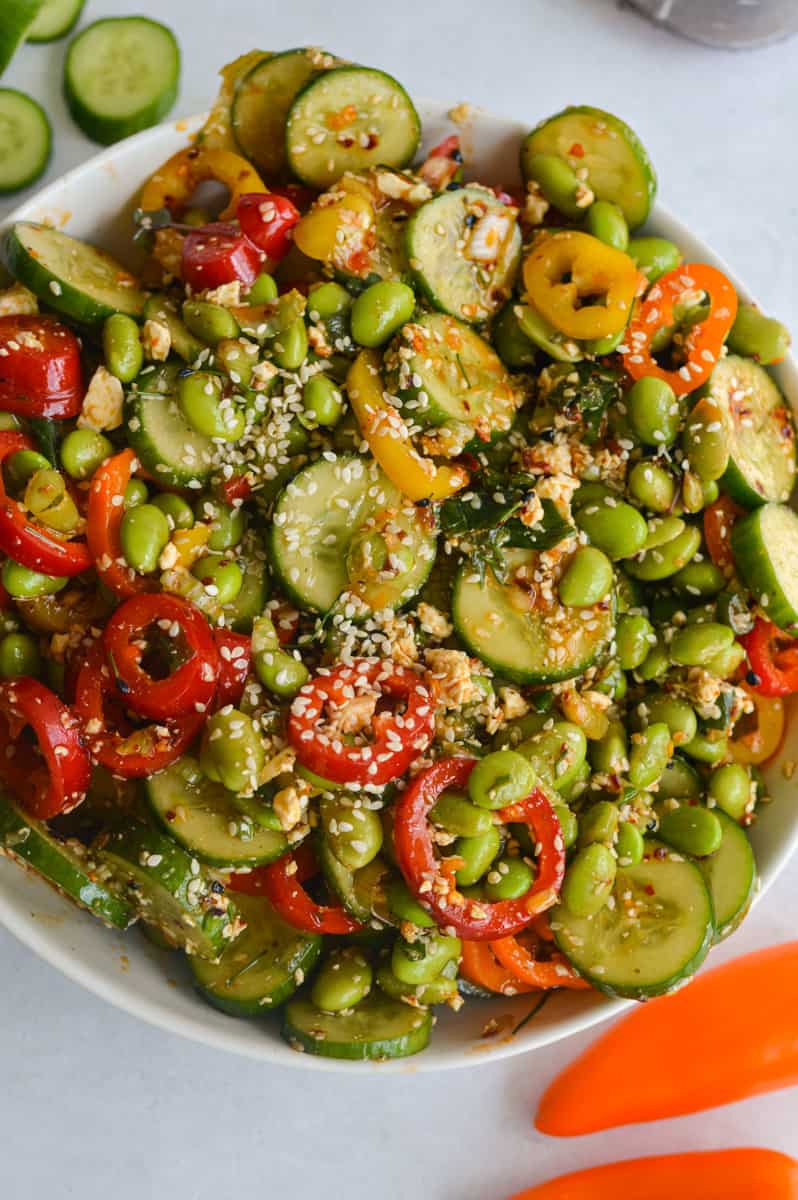 Bowl of cucumber pepper salad with edamame, chili crunch and feta cheese.