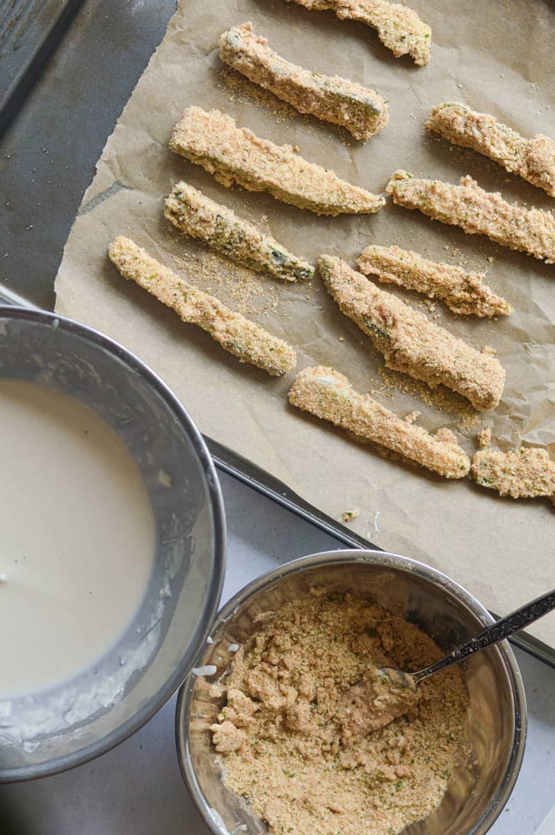Dipping zucchini fries into batter.