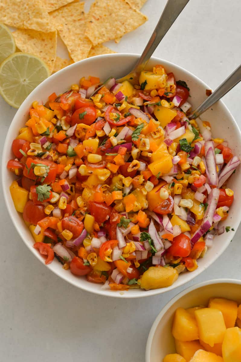 Serving mango corn salsa with a bowl of chips.