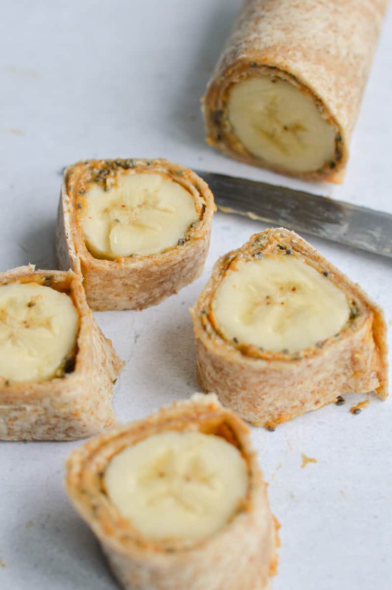 Slicing peanut butter banana roll ups into 9 pieces.