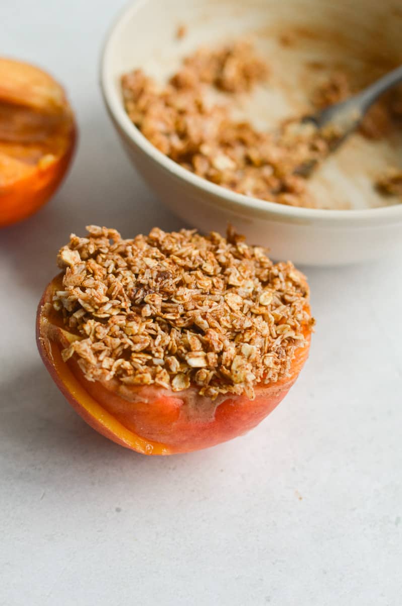 Stuffing peaches with crumble topping.