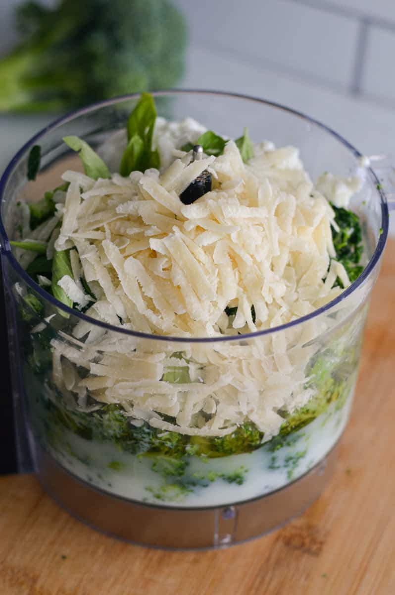Adding steamed broccoli, reserved broccoli liquid,  garlic, milk, parmesan cheese, spinach, lemon juice, salt, basil and cottage cheese to a blender.