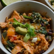 Slow cooker southwest chicken bowls topped with avocado, lime juice and green onions.