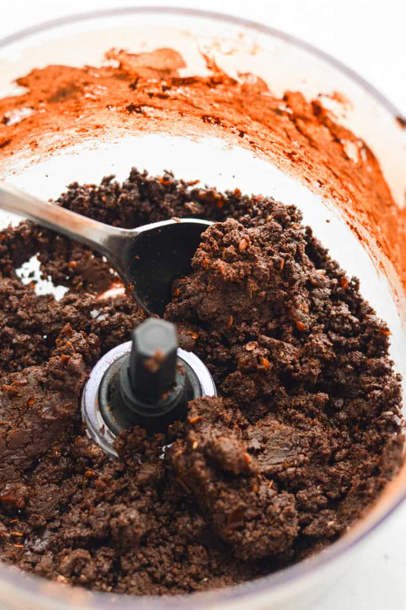 Pulsing chocolate protein bar mixture in  food processor.