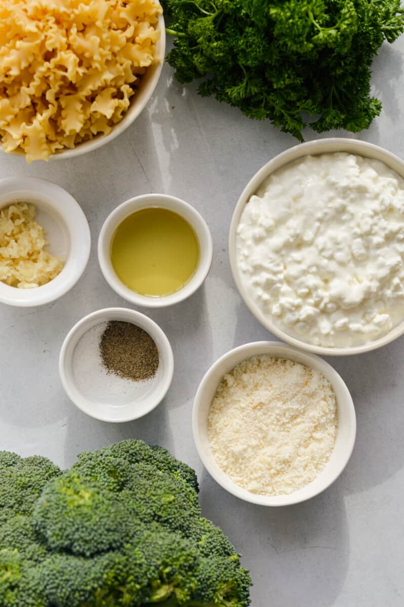 Ingredients including cottage cheese, olive oil, garlic, parmesan, pasta, broccoli, and spices.
