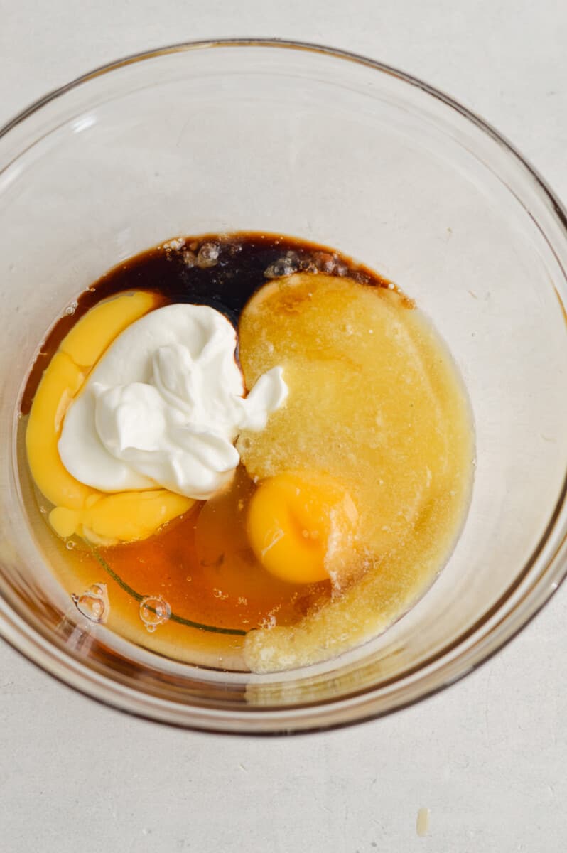Whisking eggs, maple syrup, greek yogurt, apple cider vinegar and melted butter until smooth.