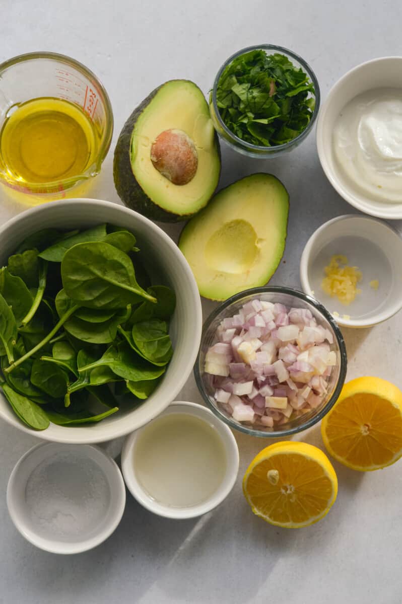 Ingredients including avocado, spinach, lemon, olive oil, herbs, shallot, Greek yogurt, garlic, rice vinegar, and dijon mustard.