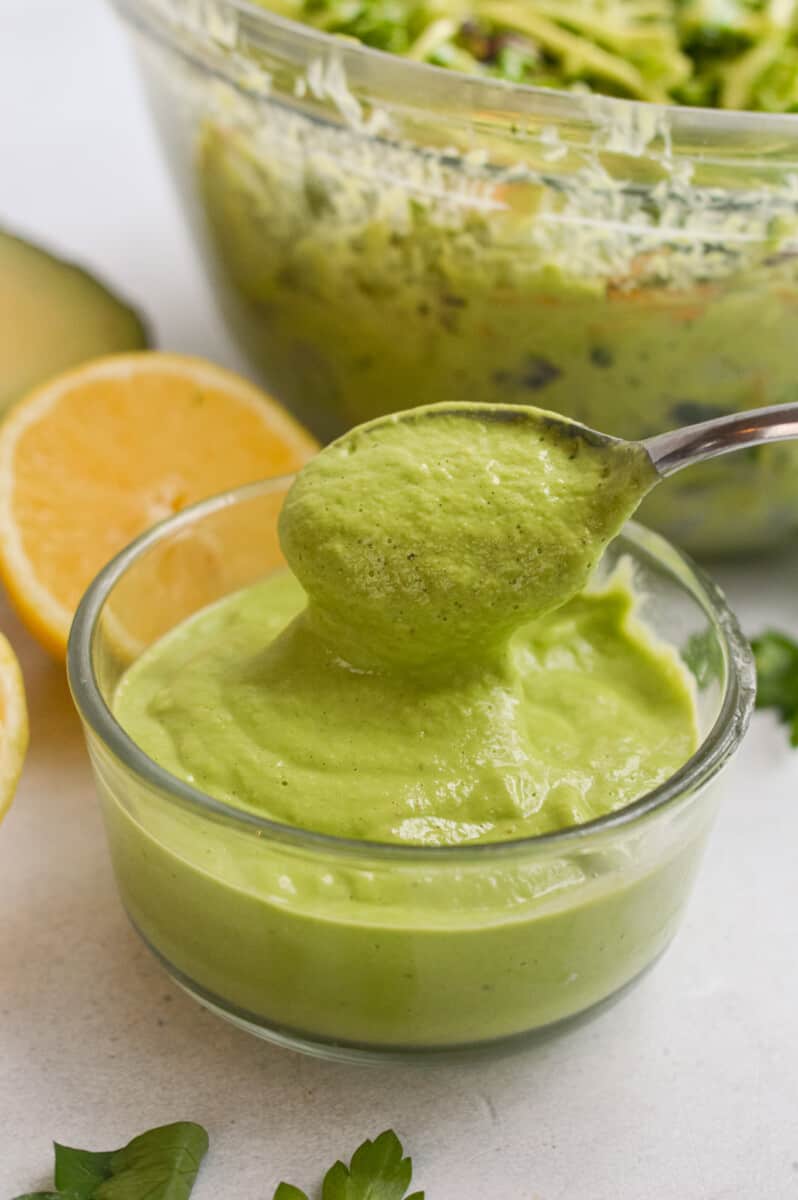 Using a spoon to scoop up avocado green goddess dressing.