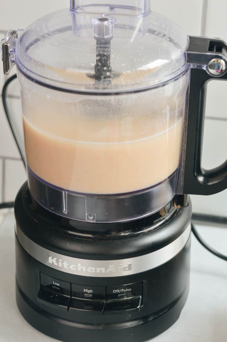 Blending white beans and chicken broth in a food processor.