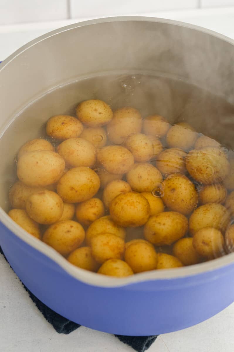 Boiling baby potatoes in a pot.