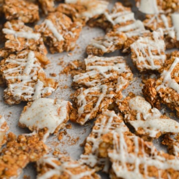 Chunks of cinnamon roll granola with white chocolate drizzle.