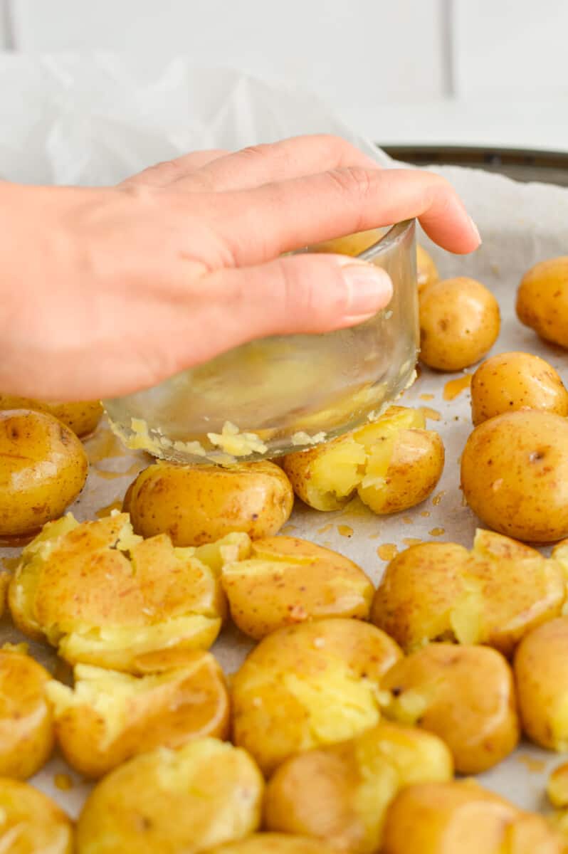 Smashing baby potatoes with a glass jar.