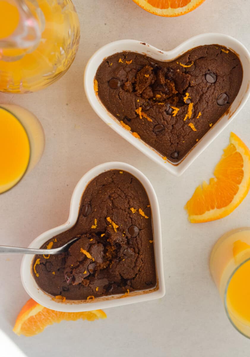 Birds eye of two chocolate orange baked oats in heart shaped ramekins.