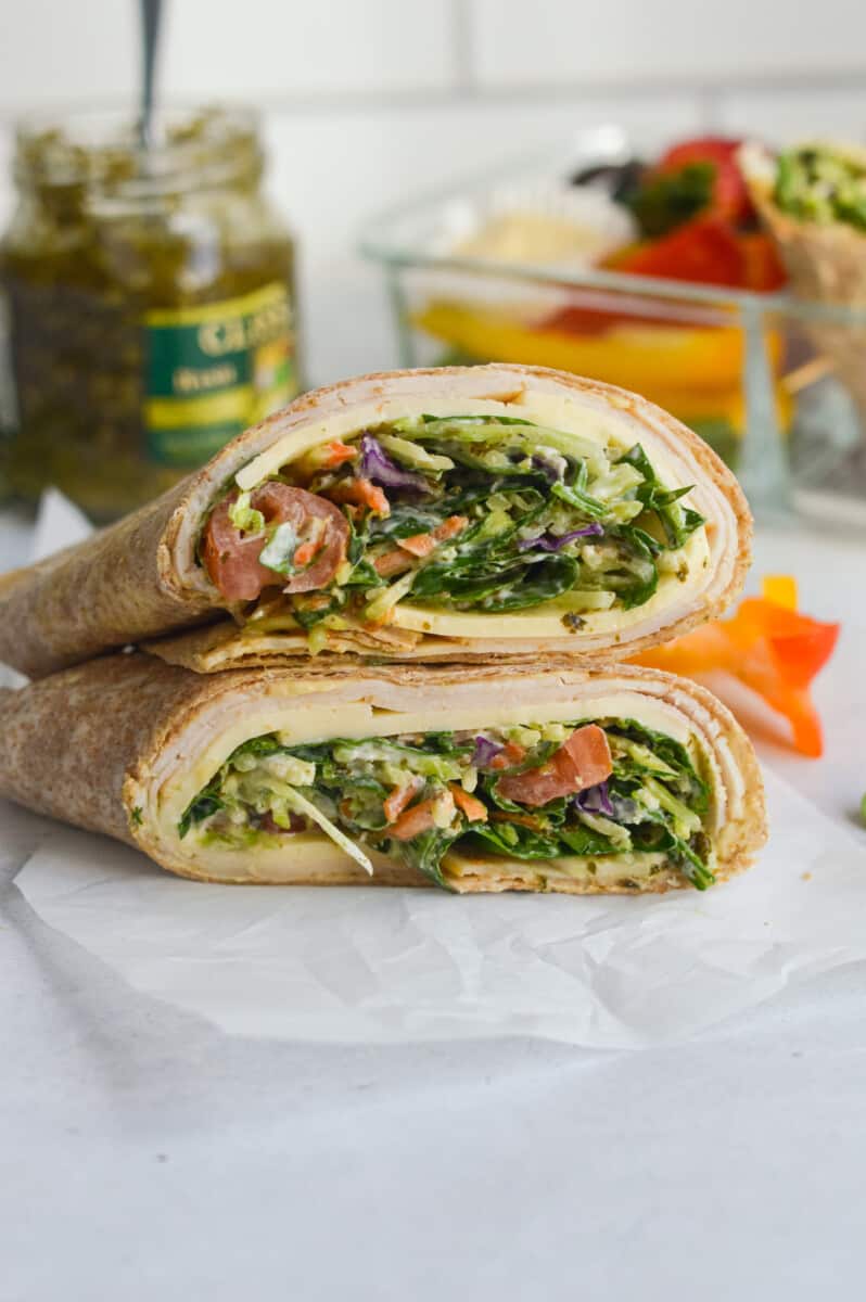 Cross section of a chicken spinach wrap with pesto, coleslaw and hummus.