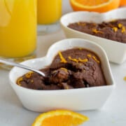 Scooping chocolate orange baked oats from a heart shaped ramekin.