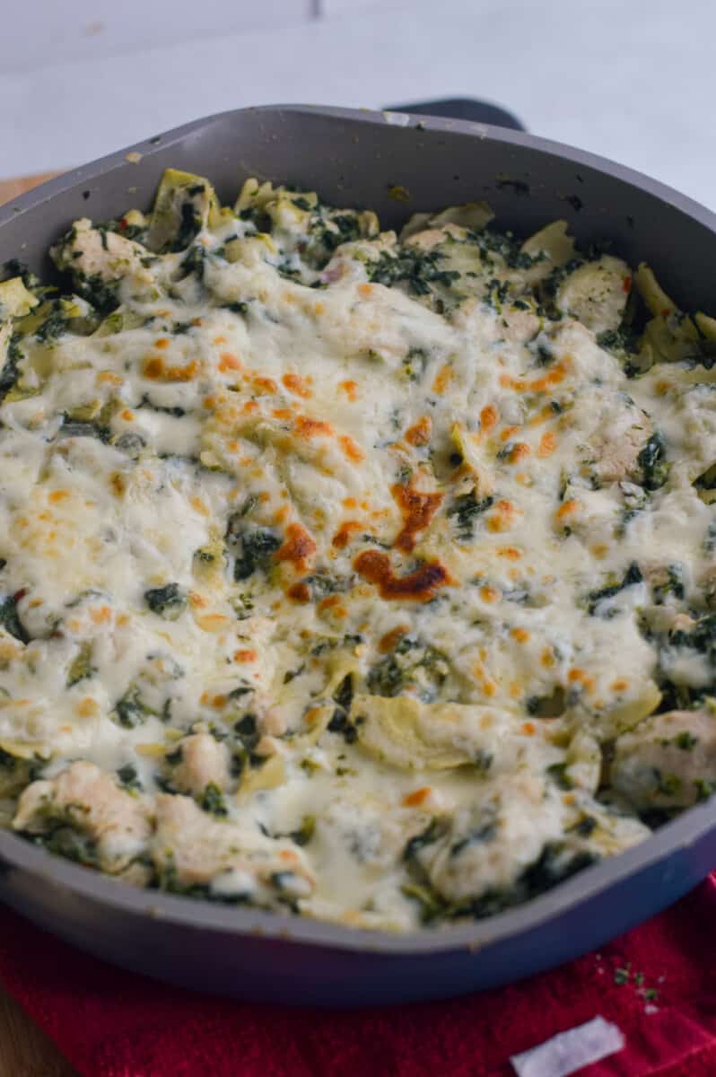 Broiling cheesy pasta with artichoke and spinach.