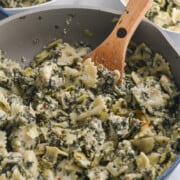 Cooking pasta with artichoke and spinach in a pan.