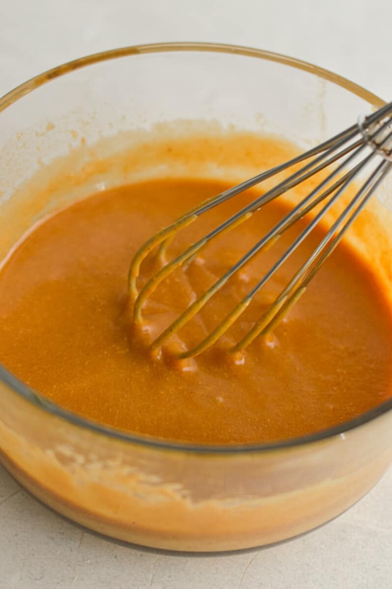 Mixing peanut butter and honey with a whisk.