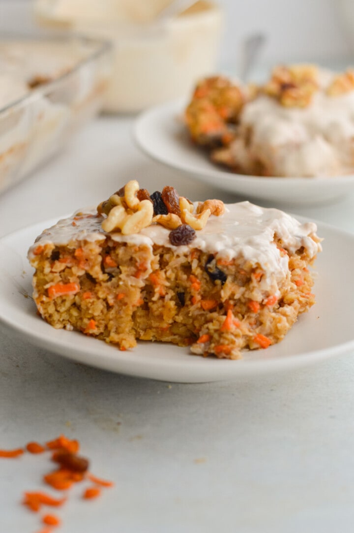 Plate with a slice of carrot cake baked oatmeal with walnuts and Greek yogurt frosting.