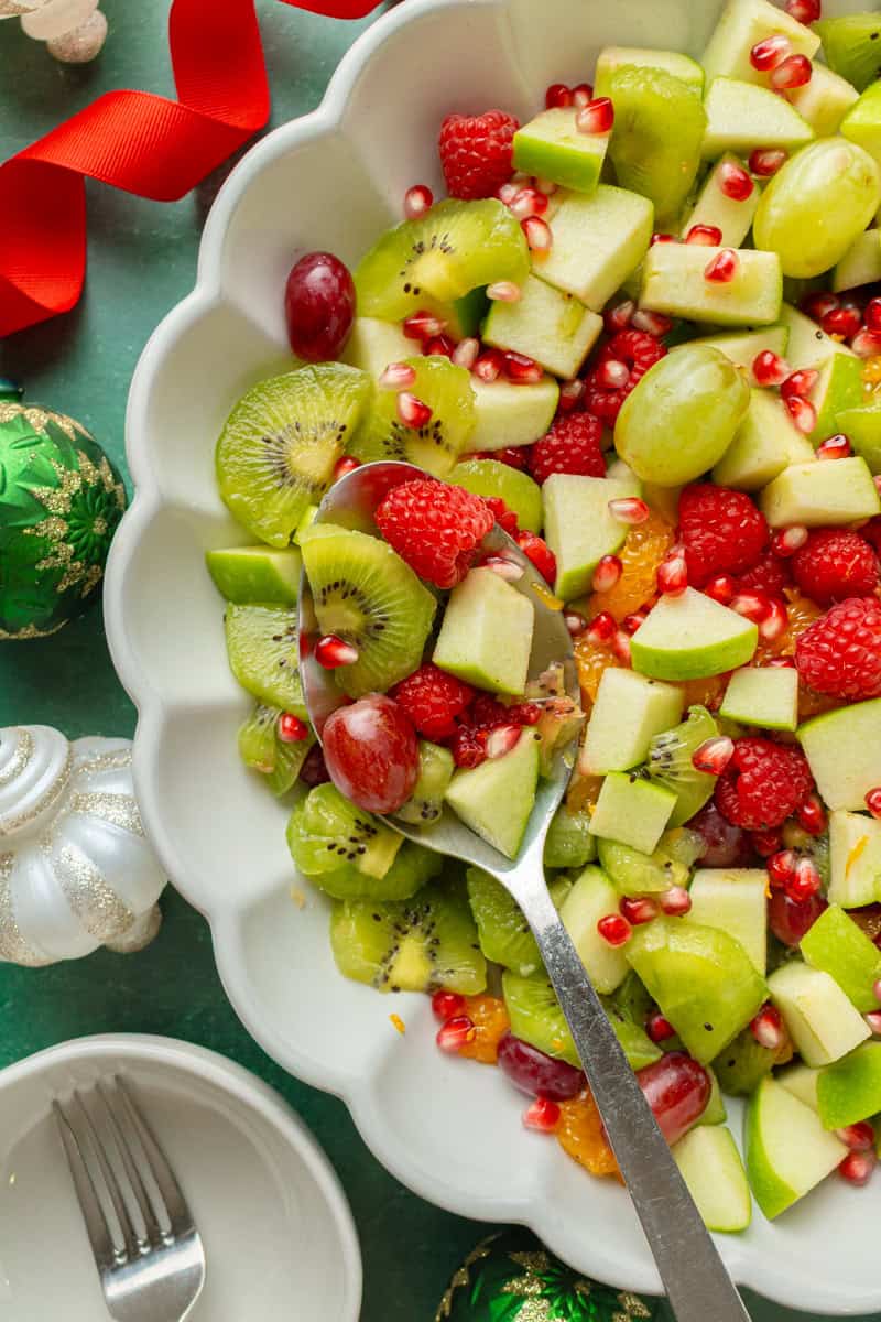 Close up of spoon lifiting up fruit salad