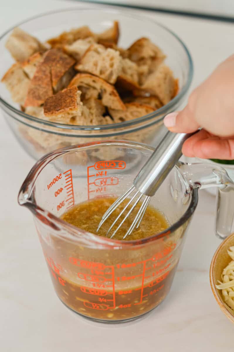 Whisking the butter, garlic, soup mix, beef broth and parsley