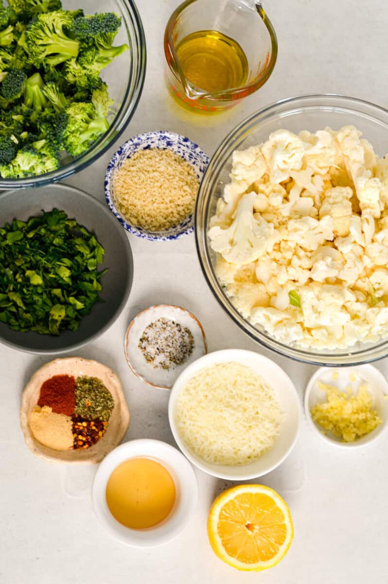 Ingredients for recipe including cauliflower, broccoli, olive oil, parmesan, spices, honey, panko breadcrumbs, lemon, and flat leafed parsley