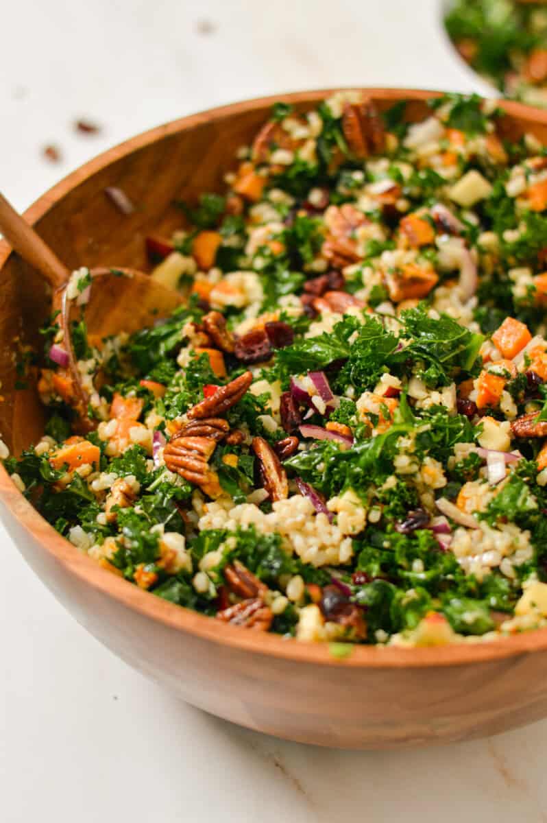 Close up of kale and roasted sweet potato salad in a large mixing bowl