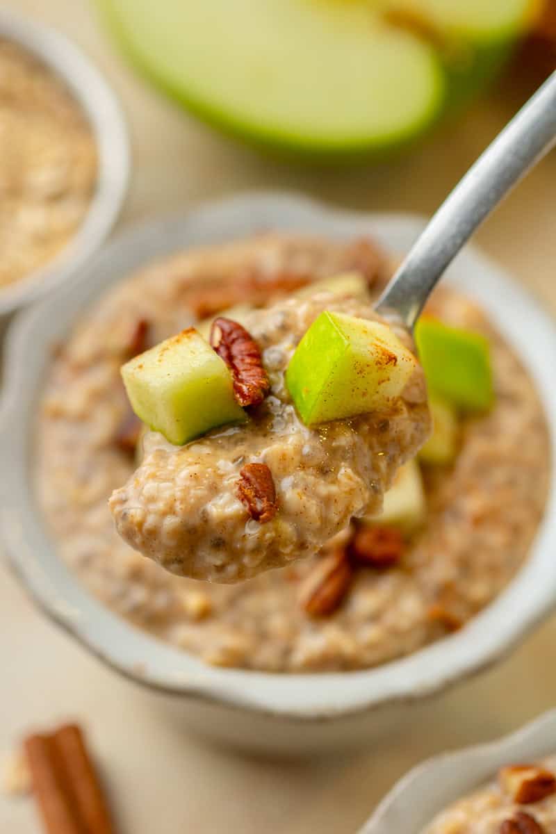 Close up of spoon lifting up the oatmeal out of a small bowl