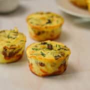Close up of three cheesy hashbrown egg cups on a countertop