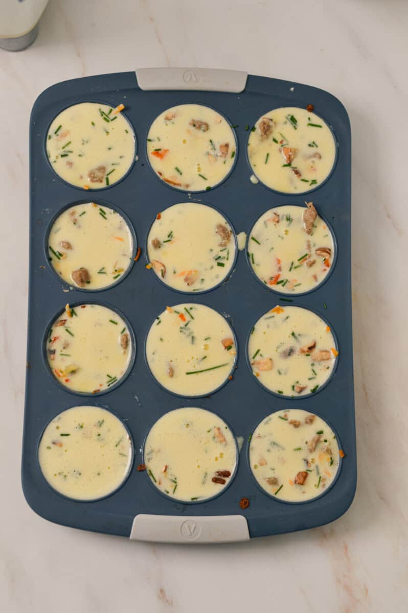 Sausage, vegetables, and egg mixture all added to the muffin tray