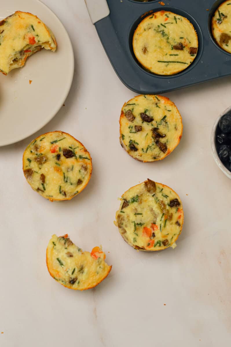 Birdseye shot of egg cups on a counter, one with a bite taken out of it