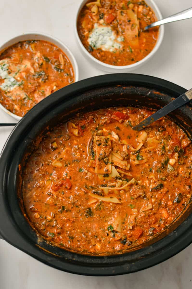 Birdseye of lasagna soup in the slow cooker and in two small bowls