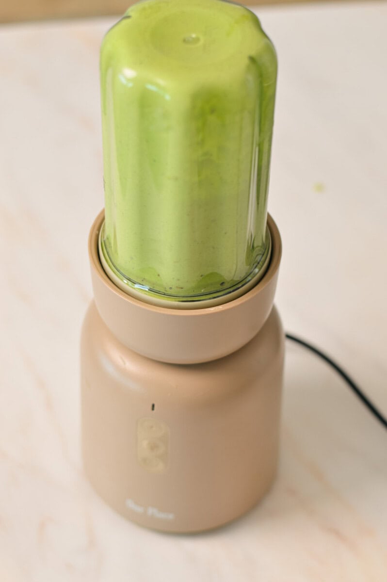 Dressing for green goddess salad being blended in a blender