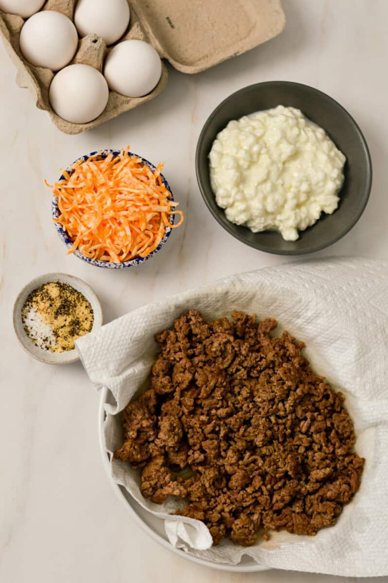 Ingredients for the base breakfast bowls including ground meat, cottage cheese, eggs, cheese and spices
