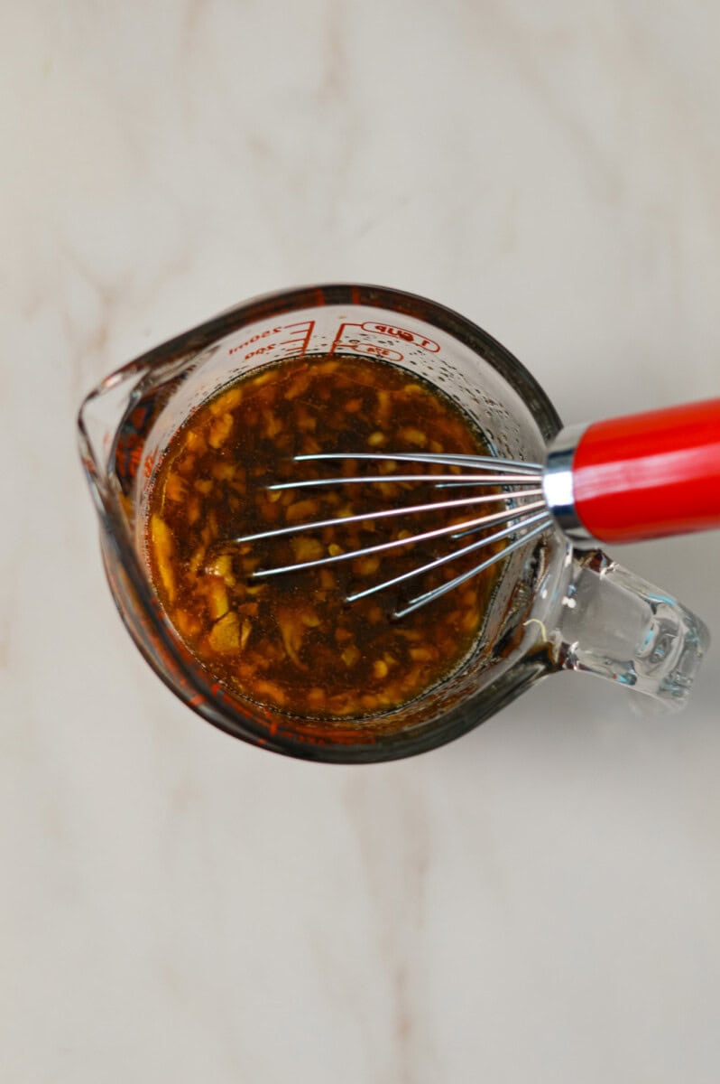 Sauce being whisked in a measuring glass
