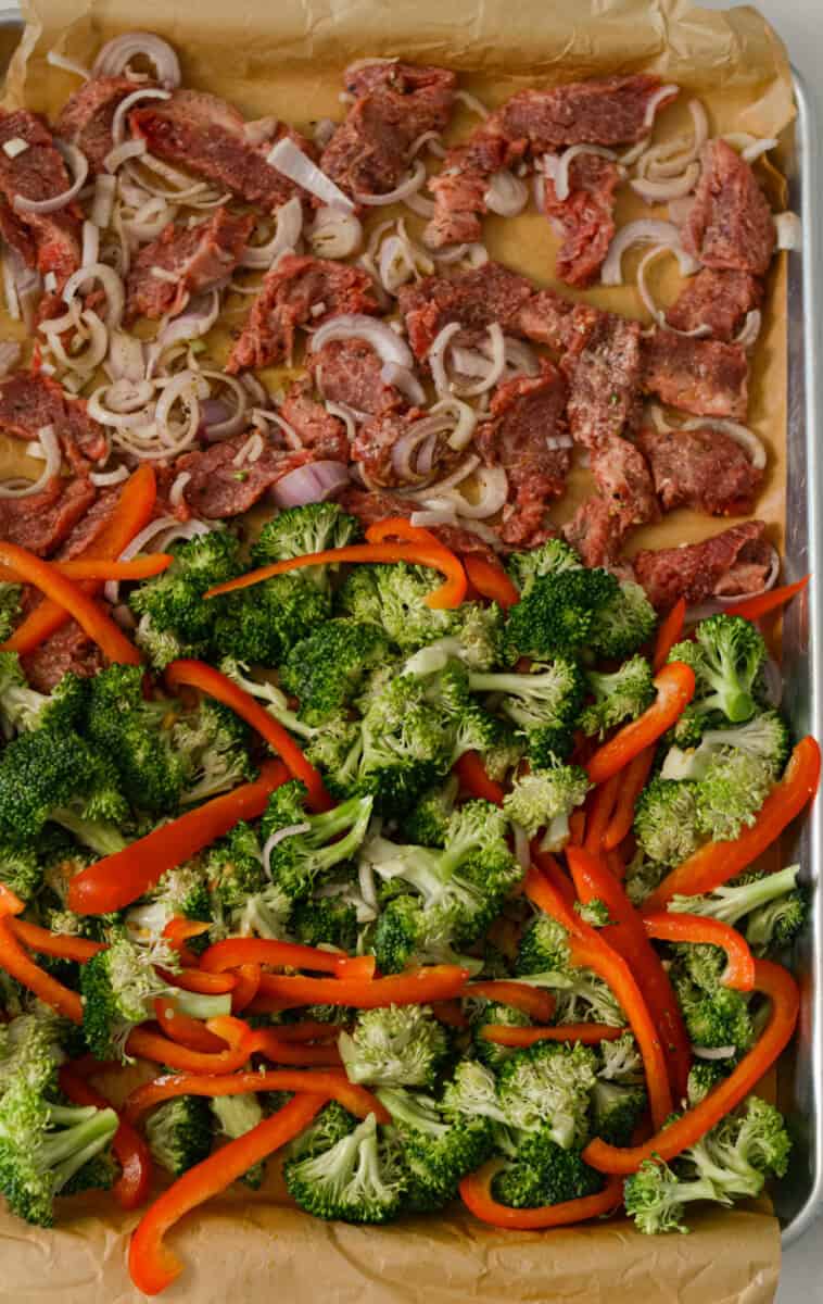 Bell peppers and broccoli added to the sheet pan