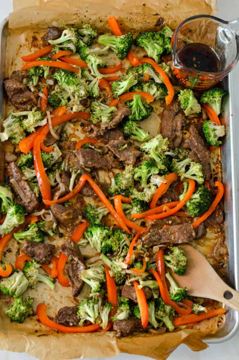 Finished sheet pan with sauce drizzled on it and vegetables added back onto the pan