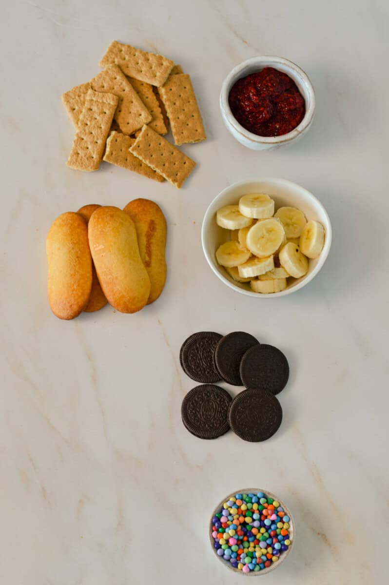 Ingredients for flavour variations including lady fingers, banana slices, oreos, sprinkles, graham crackers and chia jam