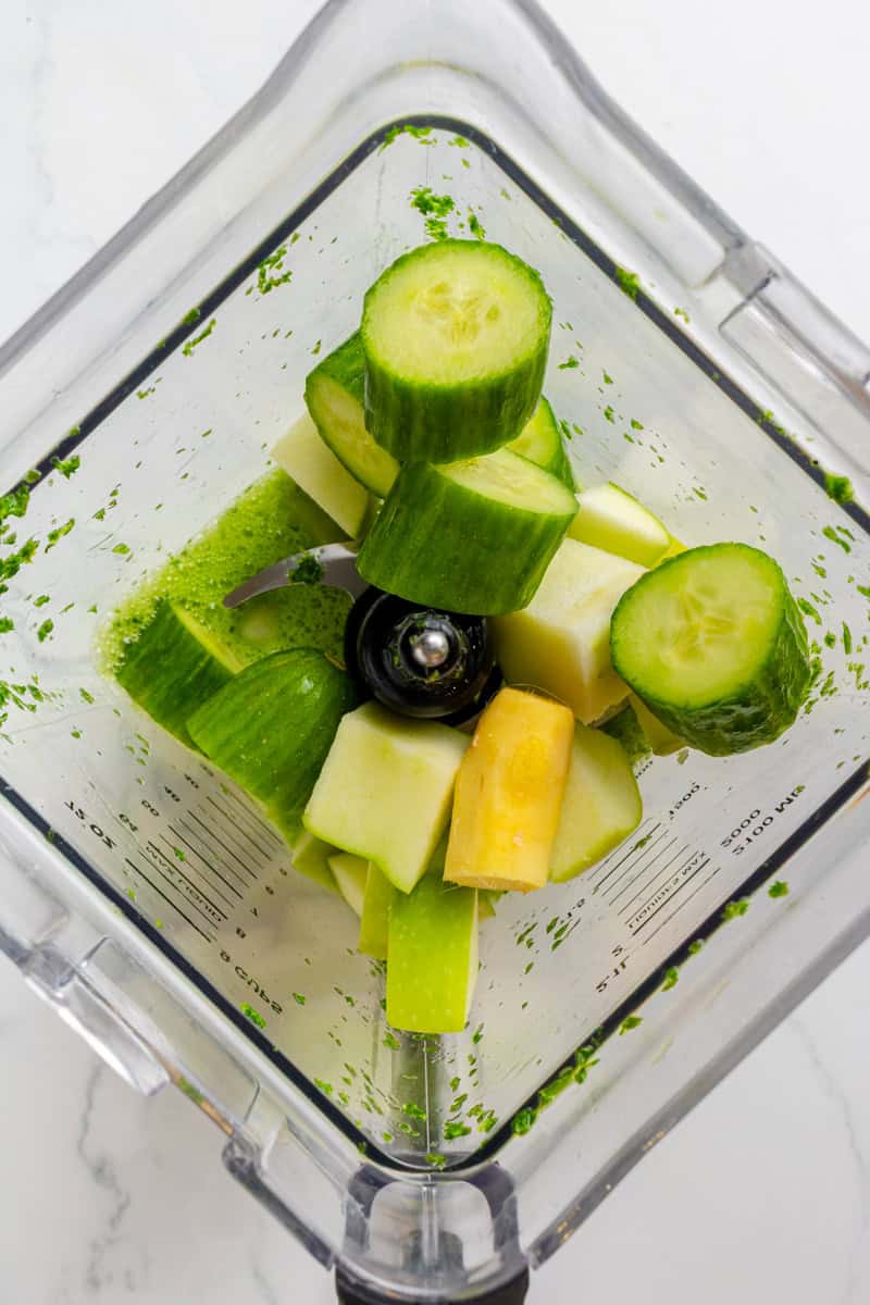 Cucumber, ginger and apple added to the blended ingredients in a blender