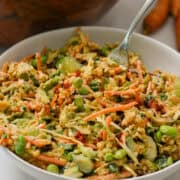 Fork lifting up salmon crispy rice salad out of a bowl