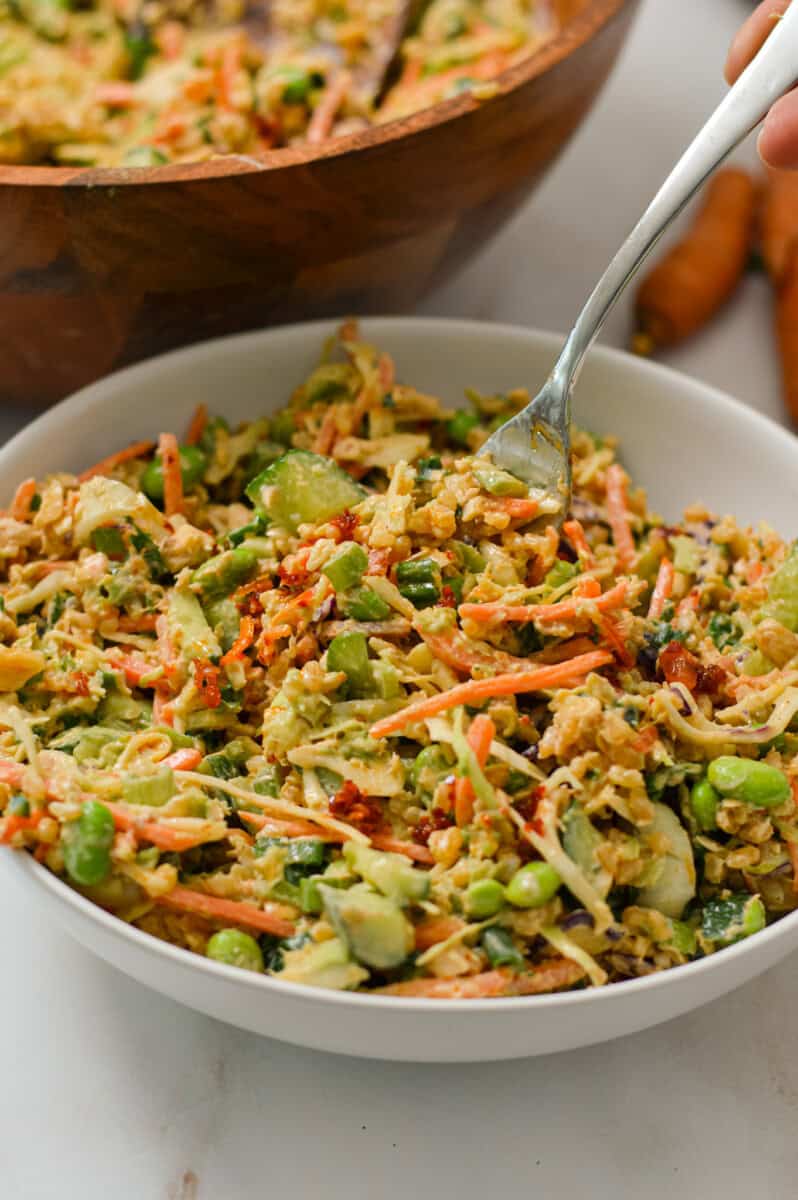 Fork lifting up salmon crispy rice salad out of a bowl