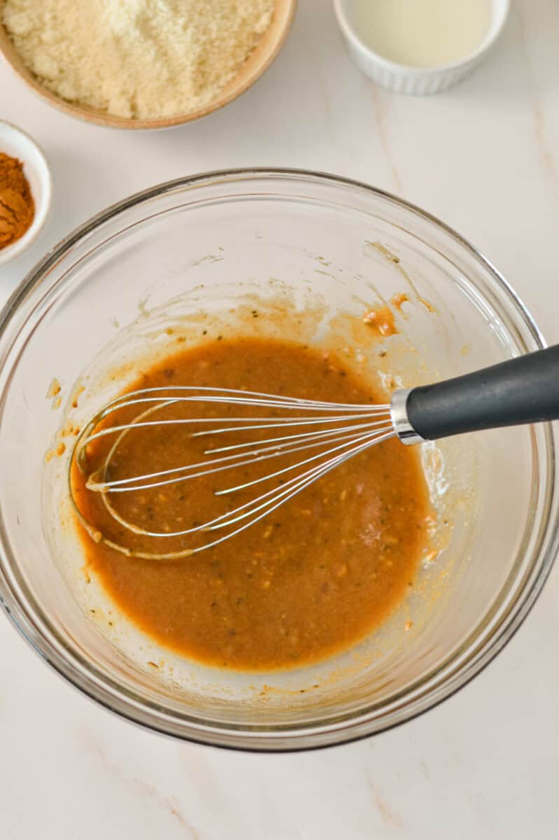 Wet ingredients combined in a bowl with a whisk