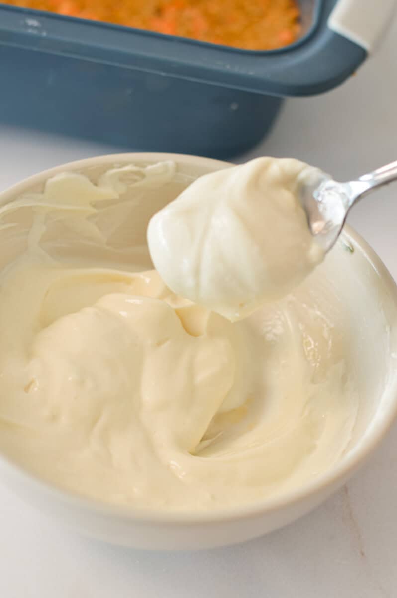 Cream cheese frosting in a small bowl with a spoon