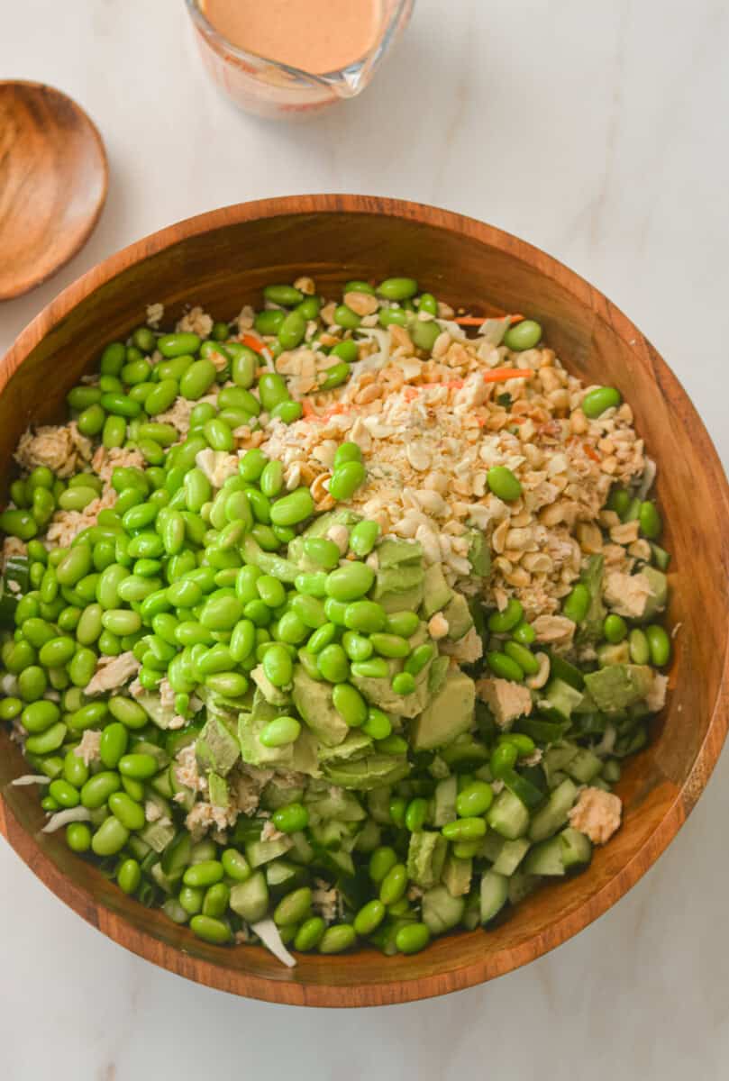 Salad ingredients added to a large bowl