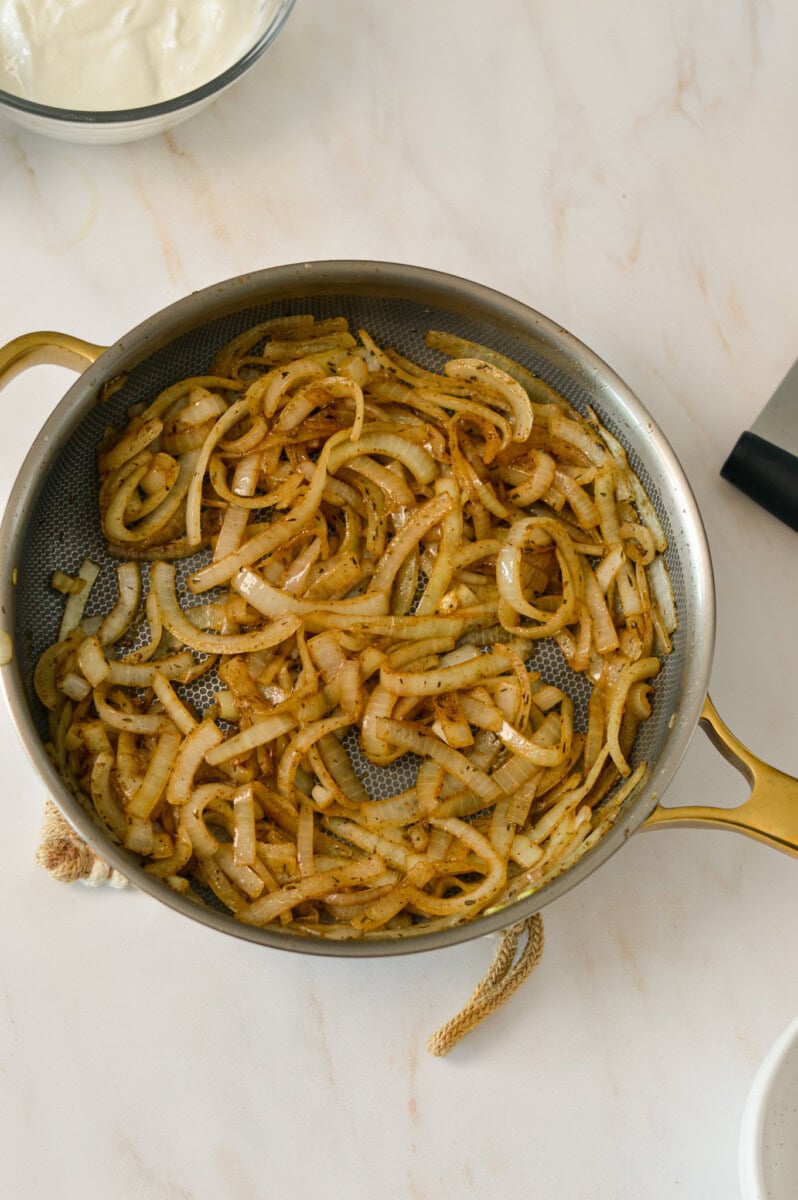 Onions being caramelized in a pan