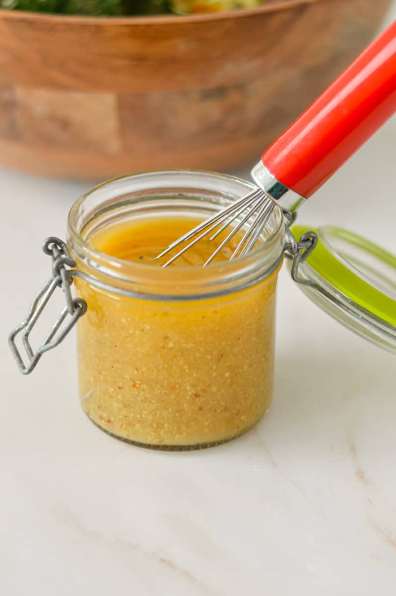Lemon dijon dressing in a small jar being whisked