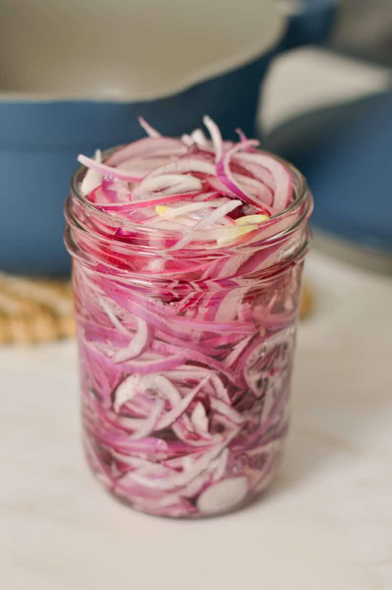 Pickled onions in a jar with vinegar