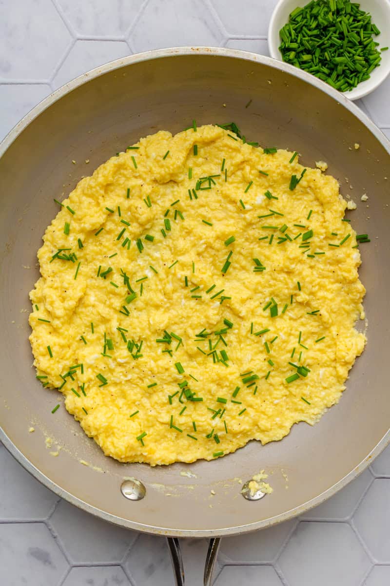 Cooked eggs in a pan with chives.