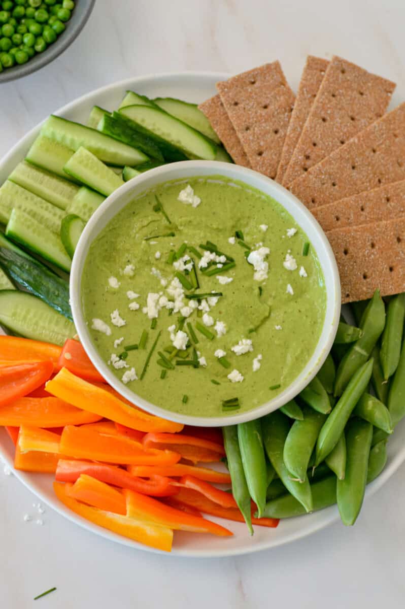 Finished hummus on a plate with veggies and crackers.