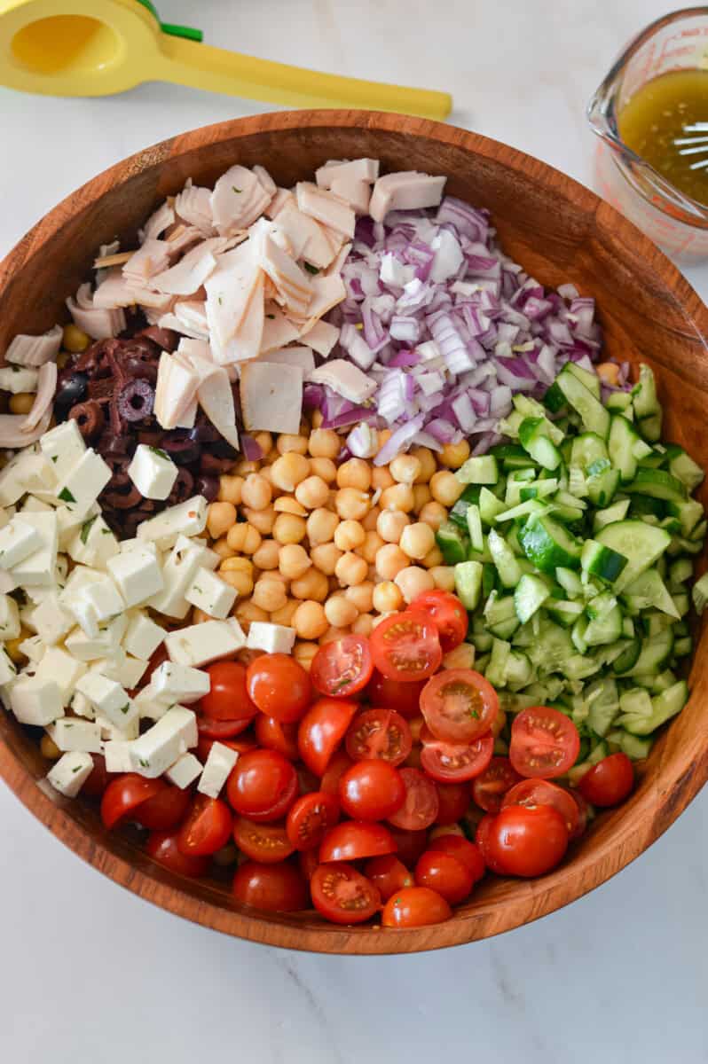 Chickpea pasta salad ingredients added to a large serving bowl.
